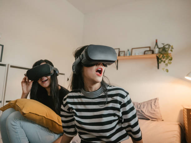 Asian couple lesbians playing a VR device at home.
