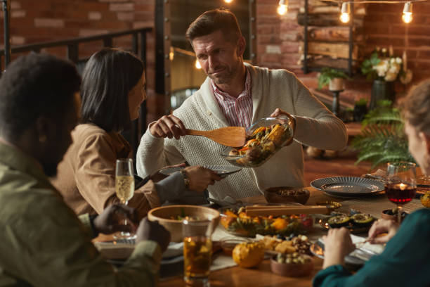 istock Man Serving Food at Dinner Party 1283716724