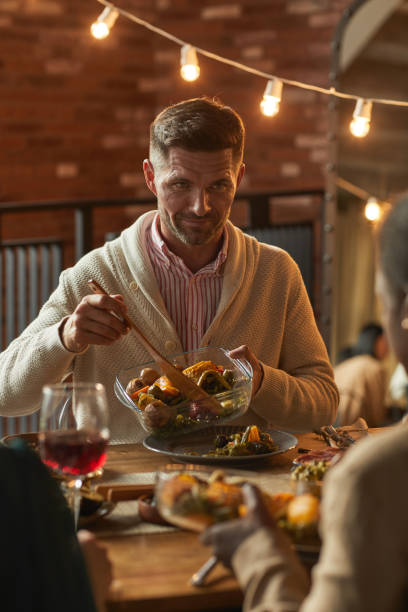 istock Mature Man Serving Food at Dinner Party 1283716725