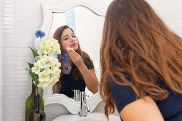istock Young woman removing makeup with a facial wipe 1283719636
