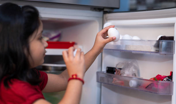 istock Little girl Picking eggs from the refrigerator 1283719886