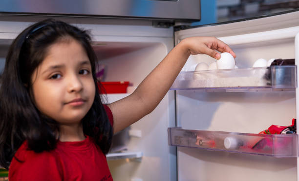 istock Little girl Picking eggs from the refrigerator 1283719932