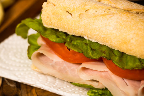 istock Ham, tomato and lettuce sandwich on a plate on a rustic background. Selective focus. 1283719985