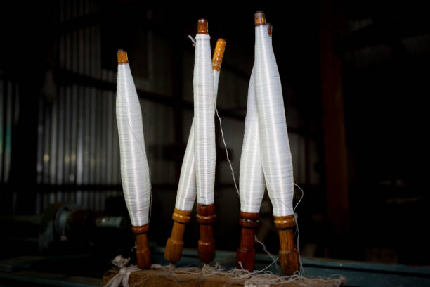 istock White yarn spools close-up in a yarn factory. White yarn spools in dark background. 1283720011