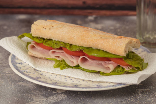 istock Ham, tomato and lettuce sandwich on a plate on a rustic background 1283720282