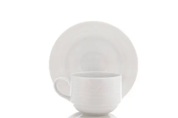A cup in front of a saucer isolated on white with reflection.