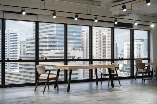 istock Empty wooden conference table with chairs in coworking space 1283720905