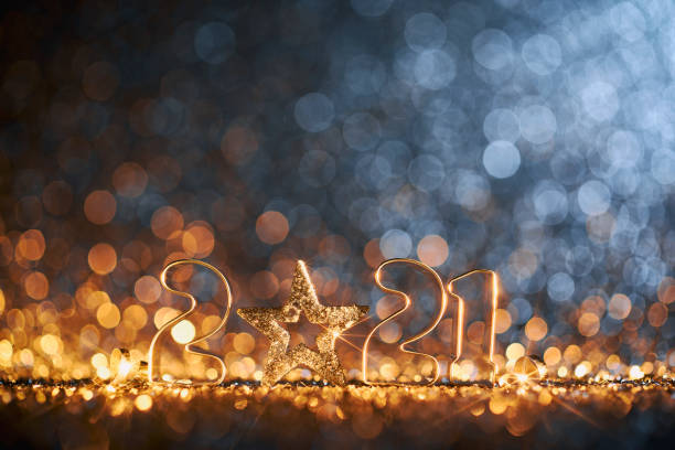 Glittering New Year 2021 Christmas Star - Gold Blue Party Celebration Background Golden numbers 2021 and Christmas decorations on glitter and defocused lights. christmas star shape christmas lights blue stock pictures, royalty-free photos & images