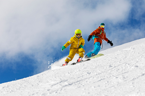 Rapid descent at high speed. Skier skiing on a sunny day in high mountains. Downhill. Ski skiing in mountains. Skiing descent at high speed. Snow dust. Sport