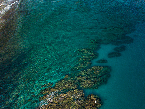 Aerial view of the Great Barrier Reef on clear sunny day with coral head atolls and natural reef patterns. Queensland, Australia.