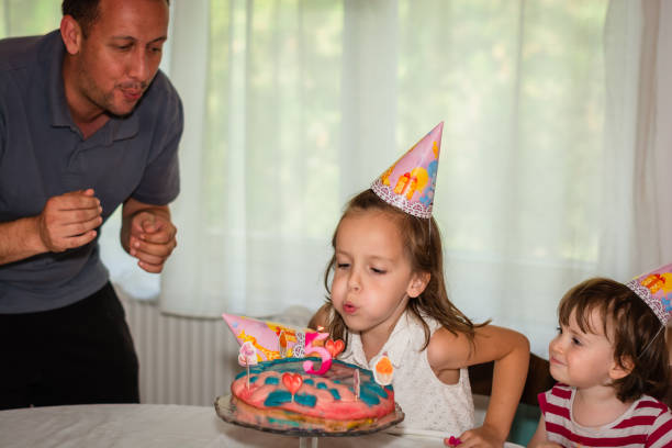 istock Child blowing birthday candle at home 1283725406