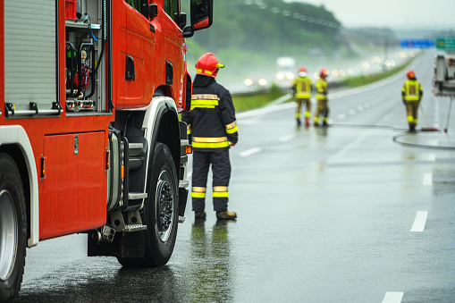 Traffic Accident Emergency Fire Crew on the Highway. Rainy Weather Poor Driving Condition.
