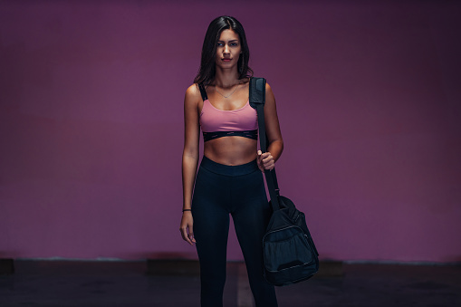 Portrait of sportswoman with gym bag going to the gym