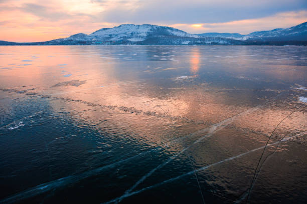 istock Ice on the frozen lake at sunset. 1283728390