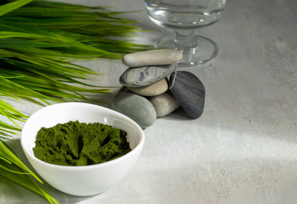 chlorella algenpulver auf einem hellen hintergrund. ein grünes superfood für eine vegetarische ernährung. kreide-schriftzug. gesundes lifestyle-konzept. spa-verfahren. ansicht von oben. kopierraum - barley grass juice green stock-fotos und bilder