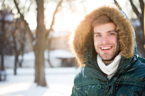 Wind resistant clothes. Winter stylish menswear. Winter outfit. Man bearded stand warm jacket snowy nature background. Hipster winter fashion outfit. Guy wear jacket with hood on frosty winter day. ropa resistente al viento. ropa de hombre con estilo de invierno. traje de invierno. hombre barbudo de pie chaqueta cálida nieve fondo de la naturaleza. traje de moda de invierno hipster. guy usar chaqueta con capucha en el día de invierno helado