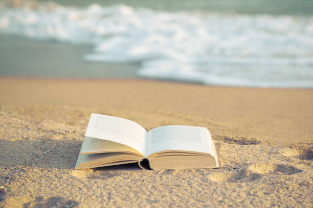 istock Bible Open book on the beach. 1283731661