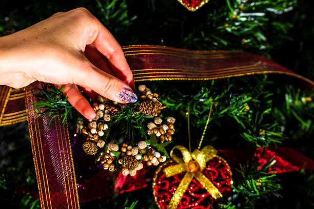 istock Decorating Christmas tree, hand putting Christmas decorations on fir branches. Christmas hanging decorations. 1283731748