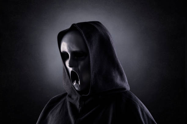 istock Ghostly figure in hooded cloak in the dark 1283731773