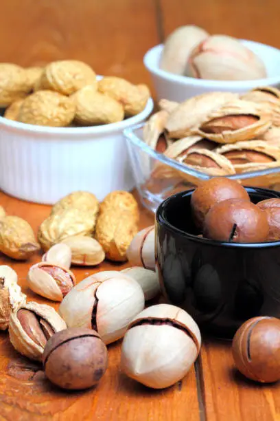 Photo of Macadamia, almonds, pistachio,  peanut,  popular, healthy, on a rustic background of wood, close-up.