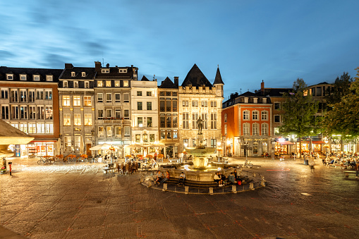 panoramic view on the illuminated facades of historic houses at Aachen market square with fountain