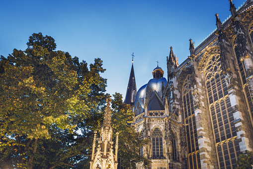 low angle view on golden illuminated Cathedral  in Aachen at blue hour