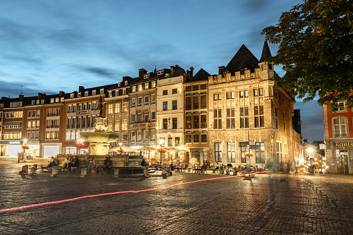 view on the illuminated facades of historic houses at Aachen market square with fountain