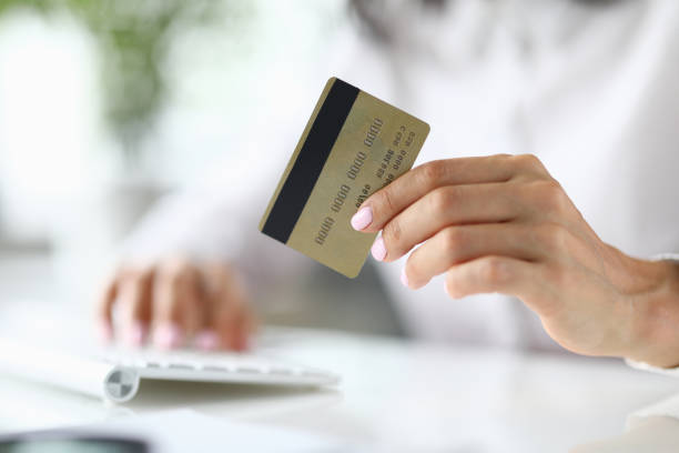 istock Female hand holds bank plastic card closeup 1283733117