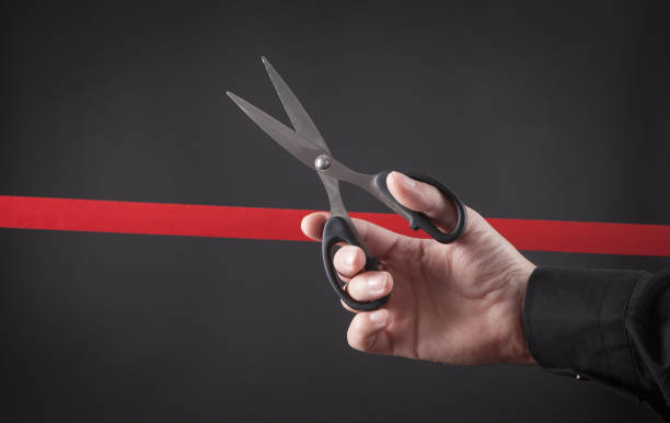 istock Male hand cutting red ribbon with a scissors. 1283735140