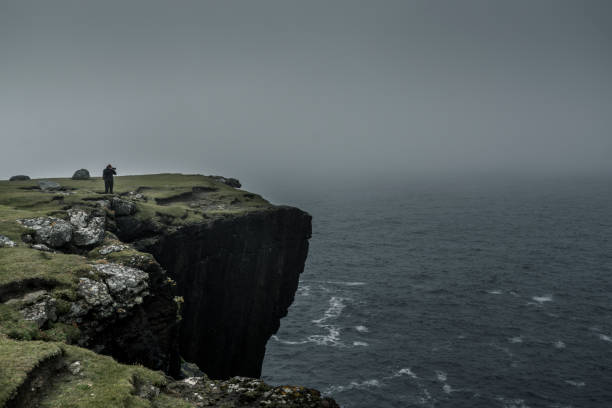 istock Silhouette of a tourist standing on a cliff top 1283736666