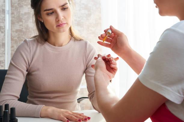 istock Cuticle care. Female hand applying oil on nails 1283738743