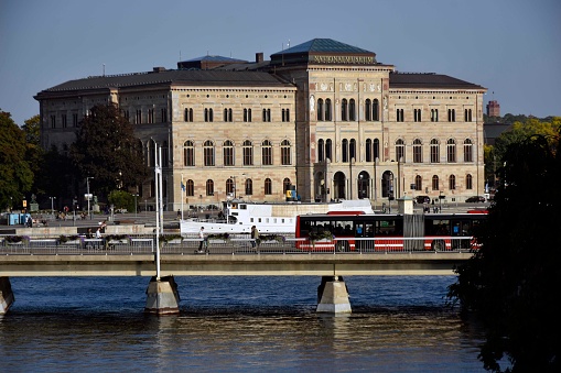 Nationalmuseum, Stockholm,Building Exterior, Bay Of Water, Docked Public Transportation Ferry, Bus, People Walking Around And More Scene In Stockholm City Sweden Northern Europe. This Swedish National Museum Holds Lots Of Famous Art Pieces
