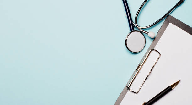 istock Stethoscope, paper and pen on a light blue background. Copy space. Flat lay 1283741699