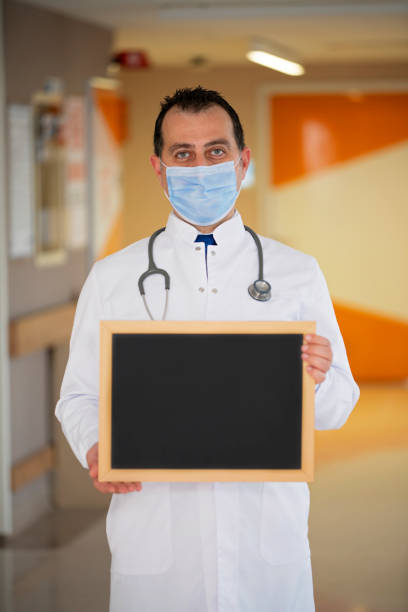 istock Doctor holding a blank blackboard. Write your message. 1283741737