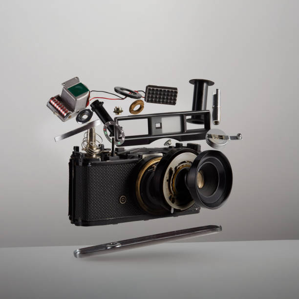 pièces et composants d’une caméra de film vintage analogique démontée flottant dans l’air sur fond blanc - work tool photos photos et images de collection
