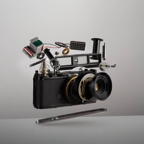 Parts and components of a disassembled analog vintage film camera floating in the air on white background Parts and components of a disassembled analog vintage film camera floating in the air on white background levitation photos stock pictures, royalty-free photos & images