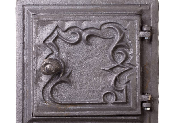 Cast iron door for furnaces. Fragment. Located on a white surface. Close-up.