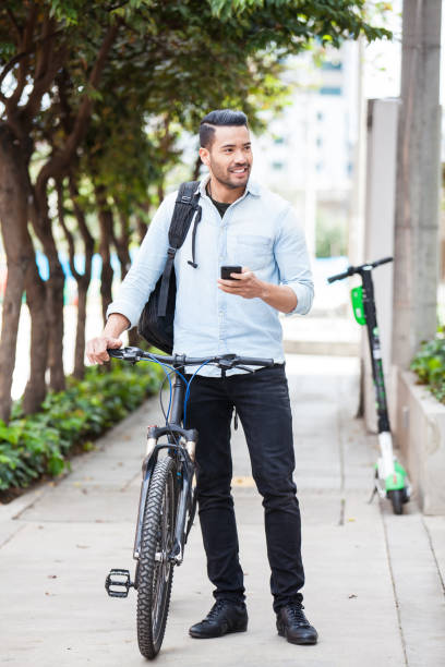 istock Man arriving to work on a bicycle and using his cell phone - mode of transport concepts 1283745763