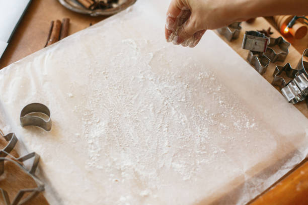 istock Hands pour flour for kneading raw gingerbread dough on rustic table. Making christmas cookies 1283746854