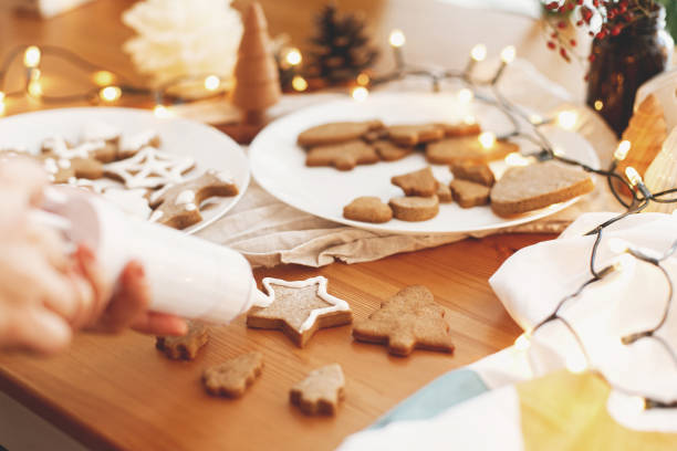 istock Decorating gingerbread cookies with icing on rustic table. Christmas holiday tradition and advent 1283747213