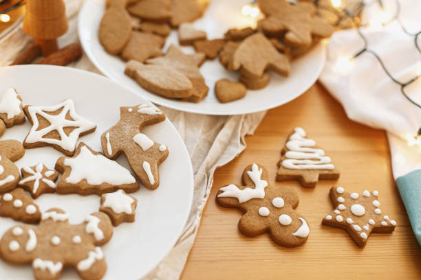 istock Gingerbread cookies with icing on wooden table with festive lights. Christmas tradition 1283747874