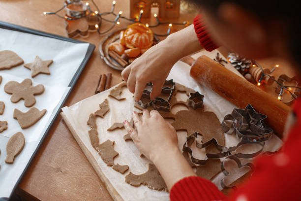 istock Hands cutting gingerbread dough with festive metal cutters on table. Making Christmas cookies 1283748005