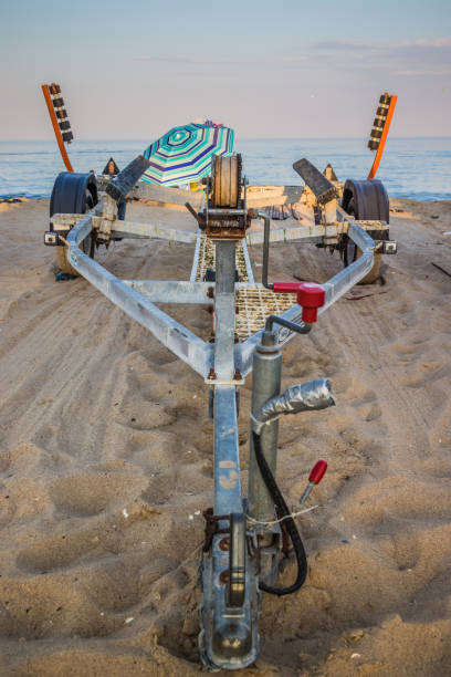 istock The boat trailer at beach. Car root ships, components Trailer for boats roots , 1283748302