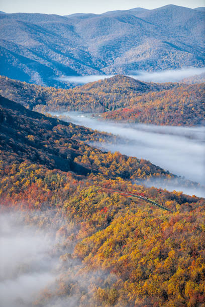 devil's knob оверлук вертикальный вид на wintergreen курортный город с блу ридж parkway шоссе в горах с осенними облаками туман тумана, охватывающих пик в� - blue ridge mountains appalachian mountains appalachian trail skyline drive стоковые фото и изображения