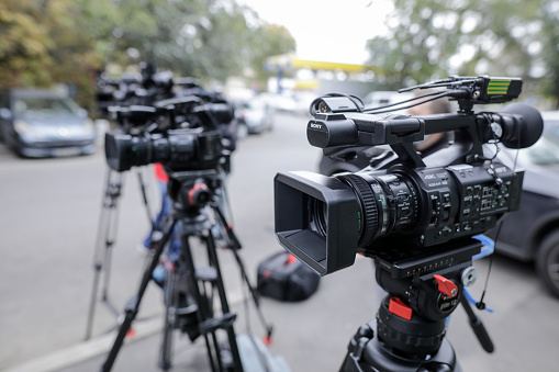 Bucharest, Romania - October 25, 2020: Shallow depth of field (selective focus) image with TV cameras on tripods on a press event in the street.