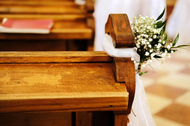 istock benches in church decorated with white flowers  for a wedding 1283751319
