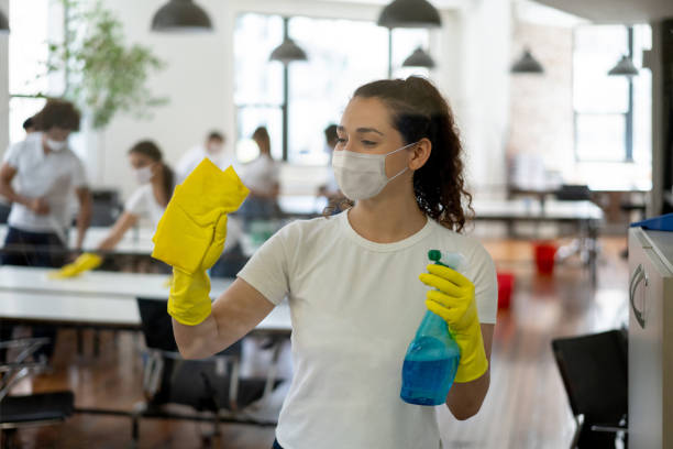 istock Professional cleaner wearing a facemask while cleaning the windows at an office 1283753301