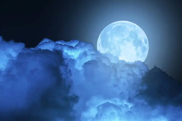 Photo of Blue super moon glowing against cloudy sky