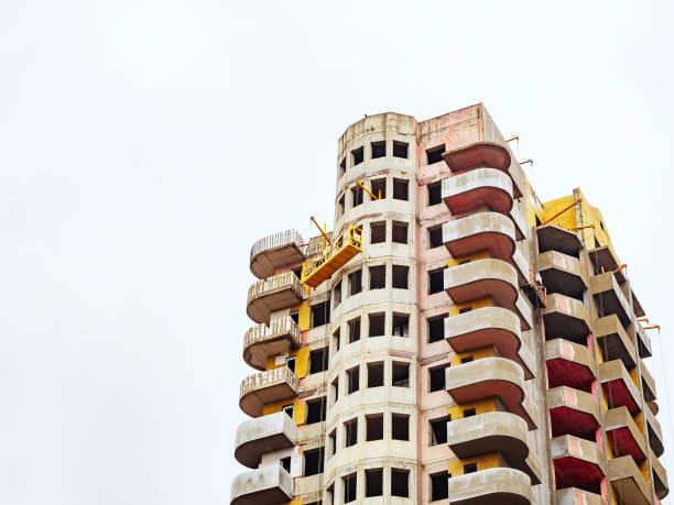 istock High-rise building under construction with rounded balconies and a construction cradle at the top. Copyspace 1283757322