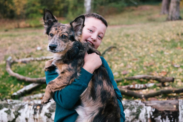 istock Boy hugging his mixed breed dog, looking at camera 1283758461